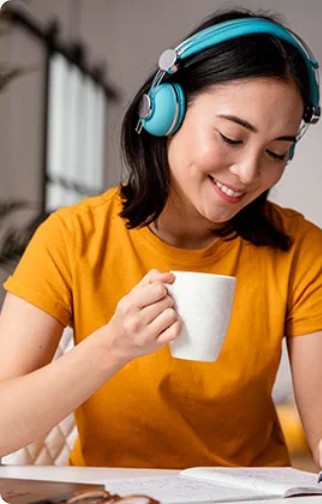 A student in headphones taking notes during an online class